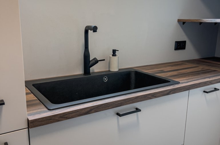 Moderní kuchyň s barem a chytrým řešením skryté spíže